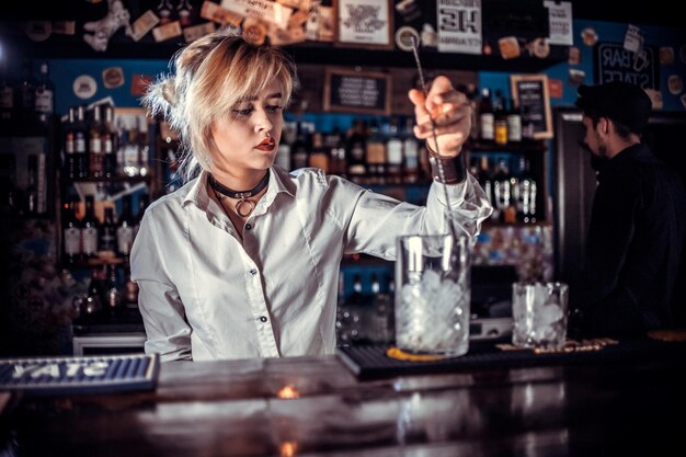 Girl bartender concocts a cocktail at the public house