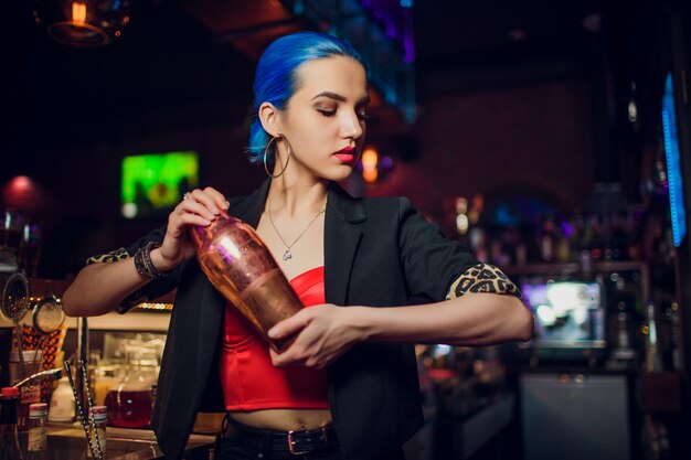 Girl bartender makes a cocktail