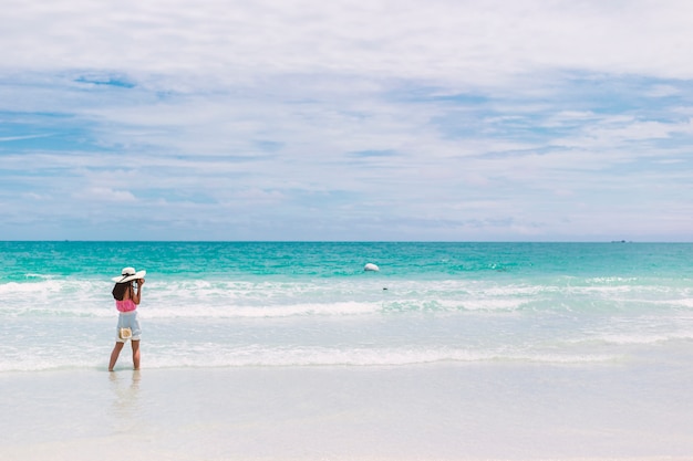 The girl on the beach. Tourists are taking pictures for fun.