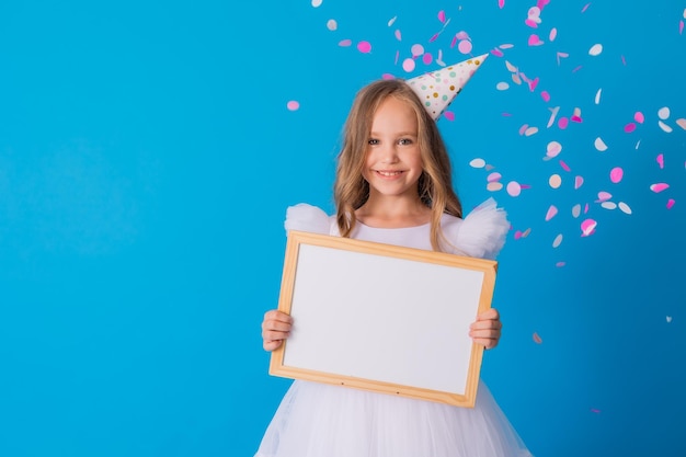 girl in a beautiful fluffy white dress holds a white writing board in her hands