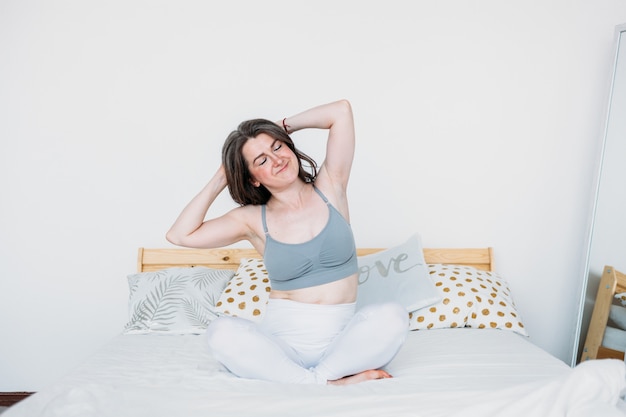 Girl in bed woke up , exercises, stretching