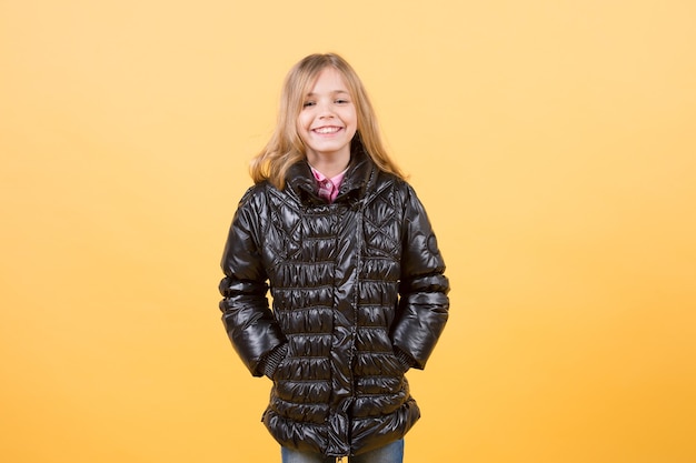 Girl in black coat on orange background