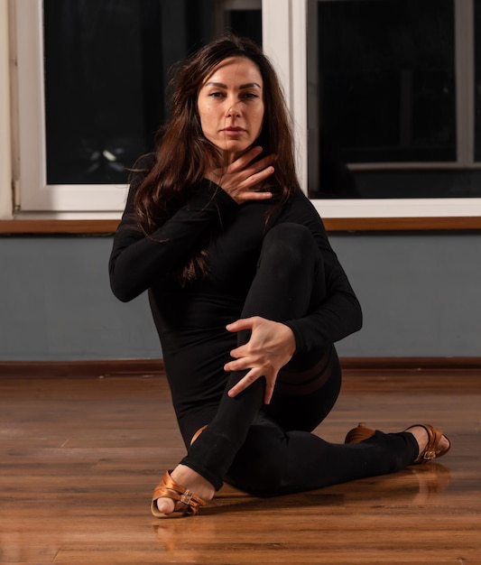 Girl in black dress are training in dance studio