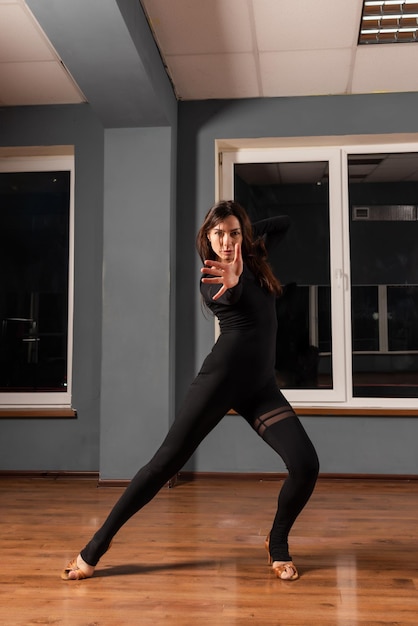 Girl in black dress are training in dance studio