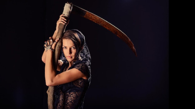 Girl in a black lace smock with scythe of death