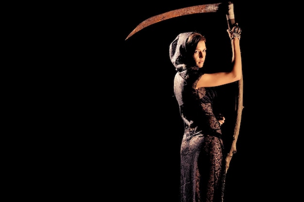 Girl in a black lace smock with scythe of death