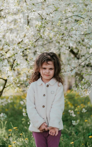 a girl in bloom nature a happy child cherry blossoms white flowers