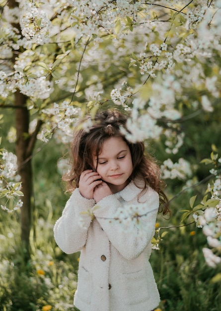 a girl in bloom nature a happy child cherry blossoms white flowers