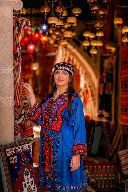 Girl in a blue national Turkish costume Photographed in a carpet store