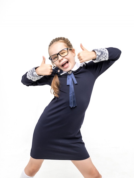 Girl in a blue school uniform emotionally posing on a white background