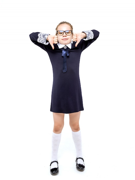 Girl in a blue school uniform emotionally posing on a white background