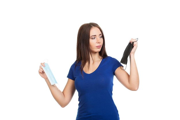 Girl in a blue Tshirt makes a choice of medical mask Isolated on a white background Concept Caring for health