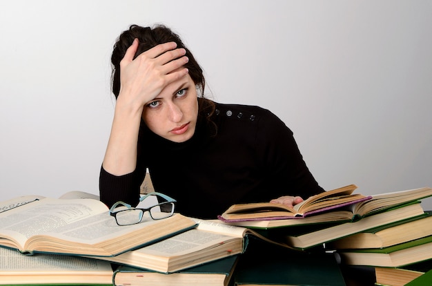 girl books exam black sweater difficulties teaches at the table tired rejoices emotions