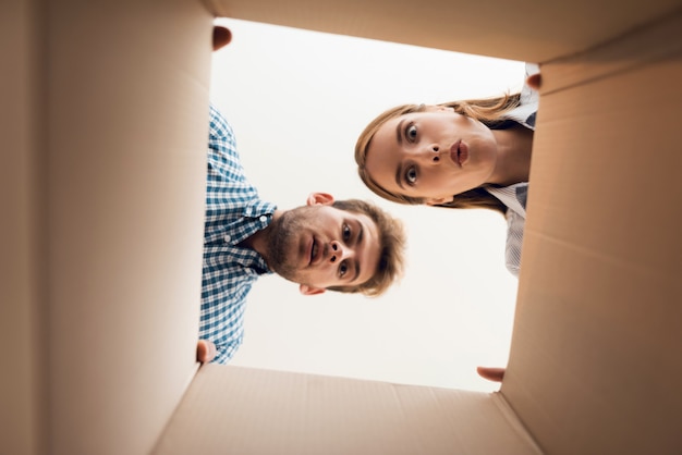 The girl and the boy are looking at the empty box.