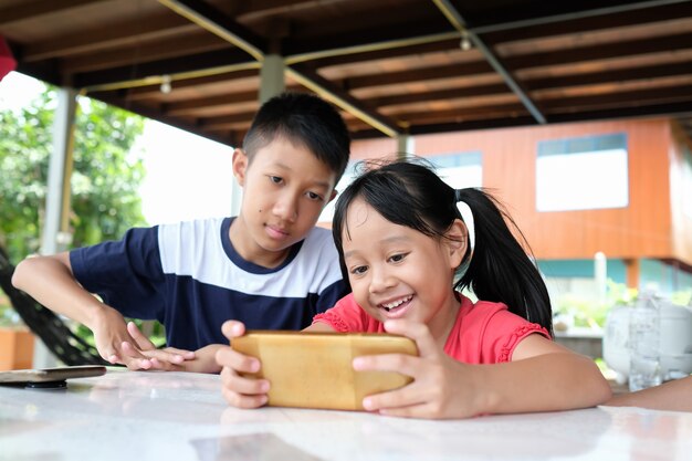 Girl and boy enjoy playing on the smartphone