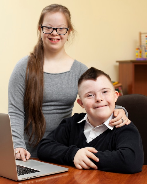 Girl and boy with down syndrome pose happily