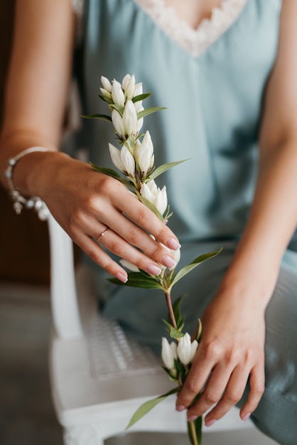 Girl bride in a gray dress holding a green twig in her hands