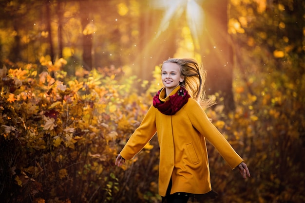 girl in a bright yellow coat running in the park