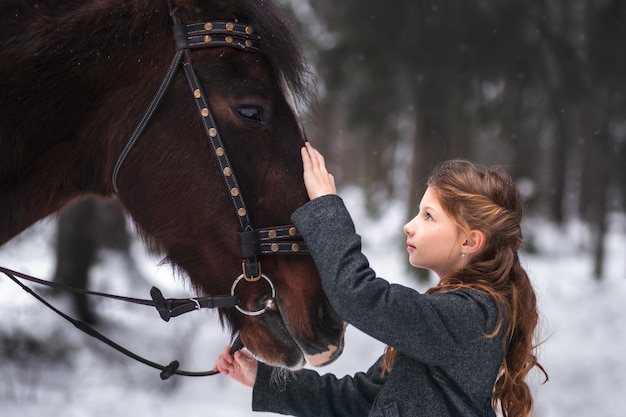 girl and brown horse in winter