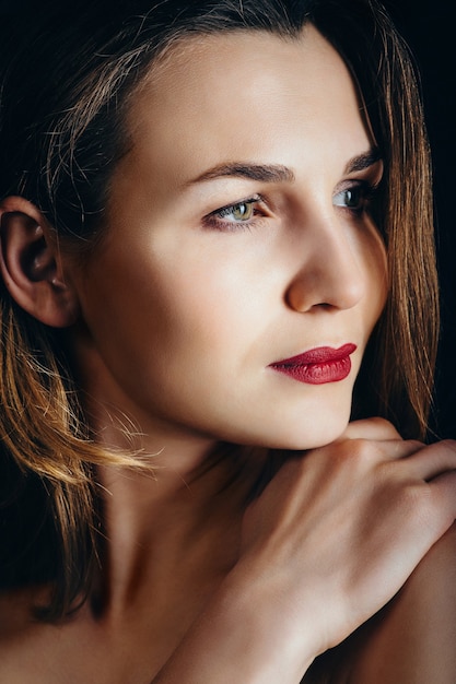 Girl brunette beauty model in a black jacket on a dark blue background