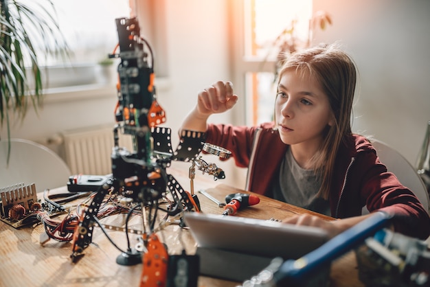 Girl building a robot at home