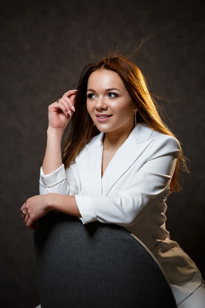 Girl businesswoman in a white jacket with beautiful hair and a smile