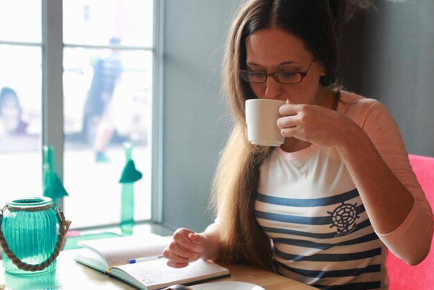 Girl in a cafe for a cup of coffee with the notebook