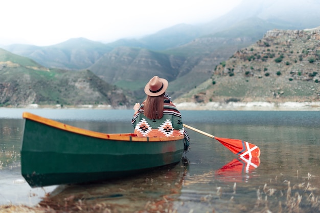 girl canoeing on a lake in the mountains on a cloudy day moody atmosphere on lake bylym