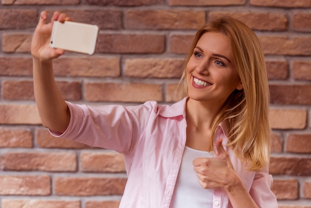 Girl in casual clothes posing, smiling and making selfie.