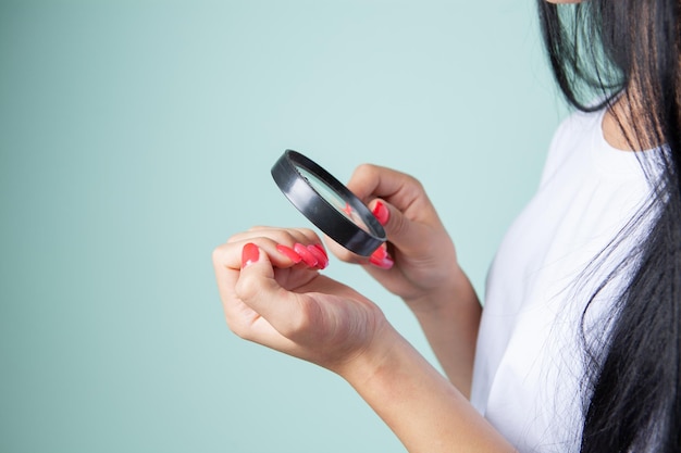 Girl checks nails with a magnifying glass