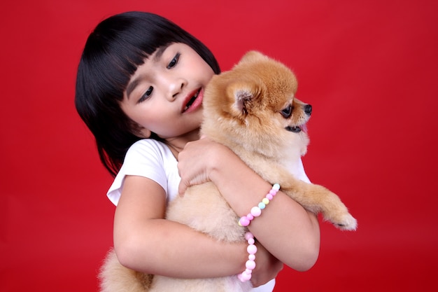 girl child Carrying a dog in studio.