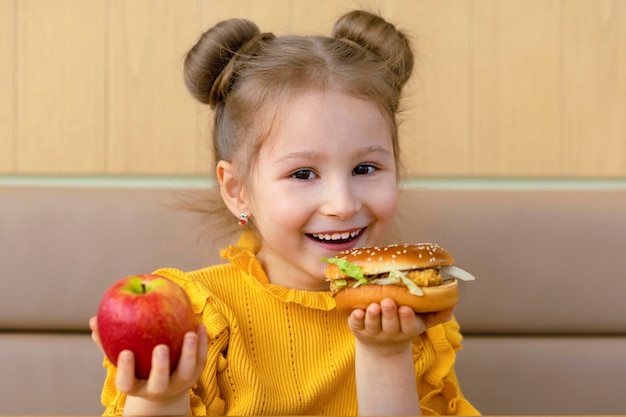 Girl choicing apple and burger healthy vs unhealthy snack kid child with fast food and fruit