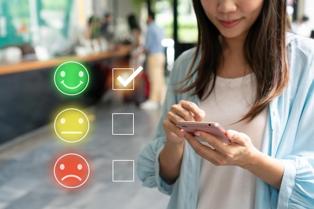 Girl choosing green happy smile face icon to give satisfaction in service Customer can evaluate quality of service leading to reputation ranking of business Customer service and satisfaction concept