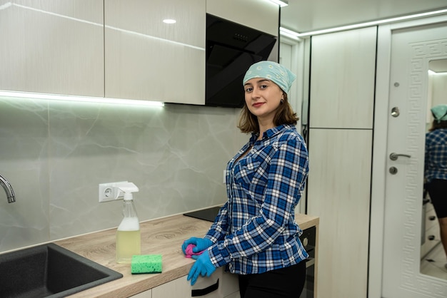 Girl cleans kitchen wearing special gloves special means dissolve remove grease from surfaces