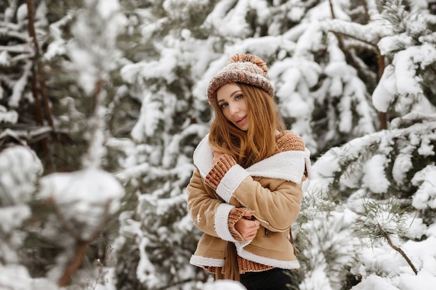 Girl cold in the winter forest with snow