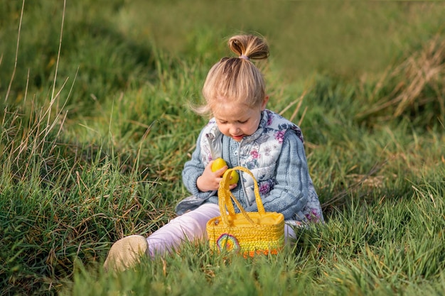 Girl collects chocolate eggs in a basket for Easter