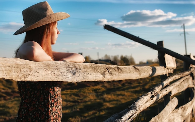 Photo girl in a cowboy hat at the fence