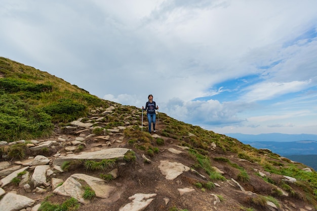 Girl descend down a large green mountain range