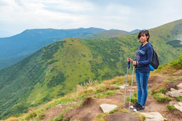 Girl descend down a large green mountain range