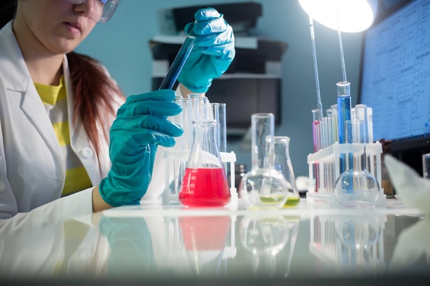 Girl at desk with laboratory test tubes, flasks