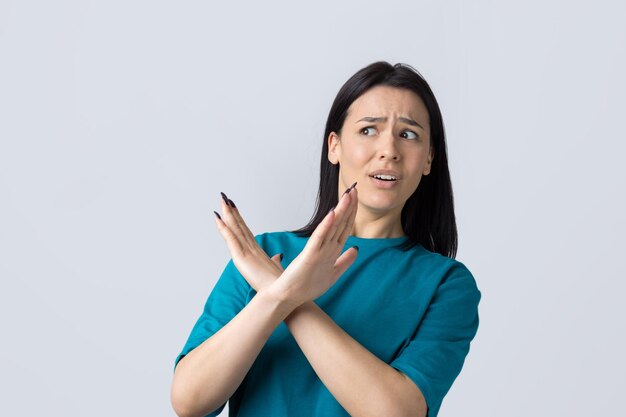 Girl disapproving with no crossing hands sign make negation gesture Portrait of pretty woman on grey background