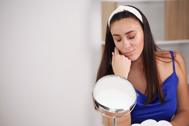 Girl does skin care, at home, in a nightgown