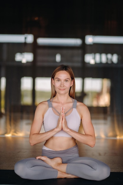 The girl does yoga A woman in sports clothes does yoga exercises in the gym