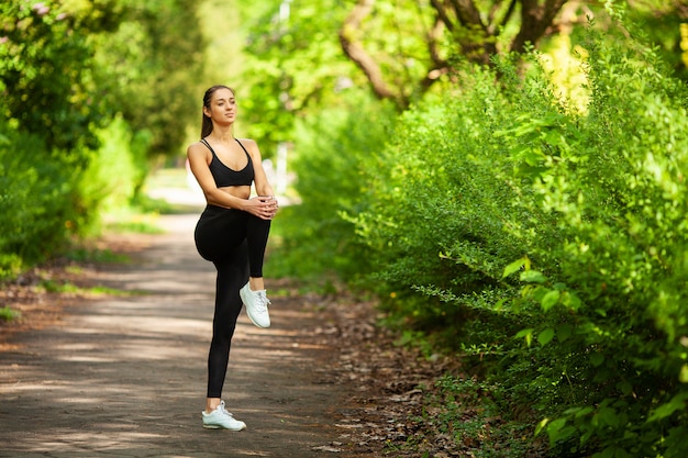 Girl doing sport. Young Female Exercising in a Park