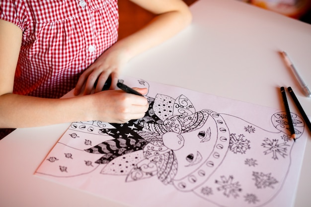 girl drawing santa claus. Christmas and New Year theme, yellow bokeh