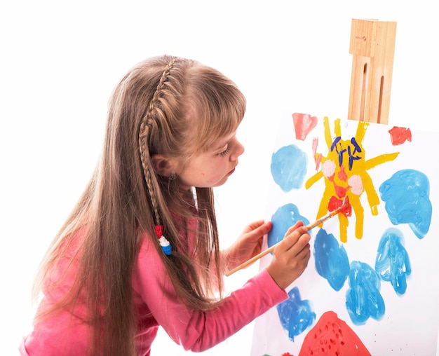 Girl draws a house and the sun artist kid girl painting over white background