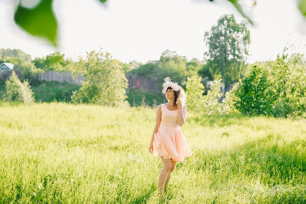 girl in a dress of Caucasian appearance with a wreath on her head on a meadow