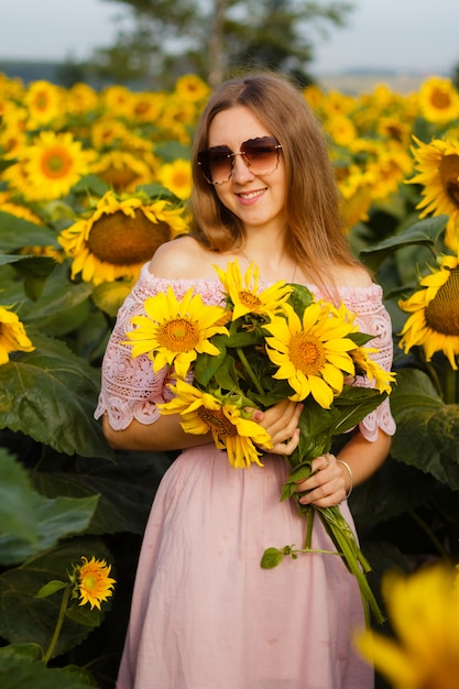 Girl in a dress among the sunflowers, the girl stands in a field of sunflowers