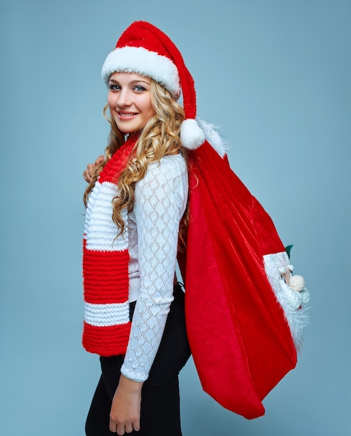 Photo girl dressed in santa hat holding a christmas decoration