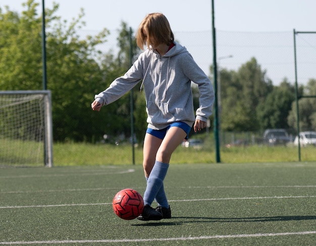 Photo girl dribbles ball on soccer field